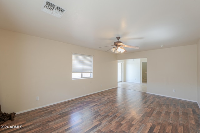 empty room with dark hardwood / wood-style floors and ceiling fan