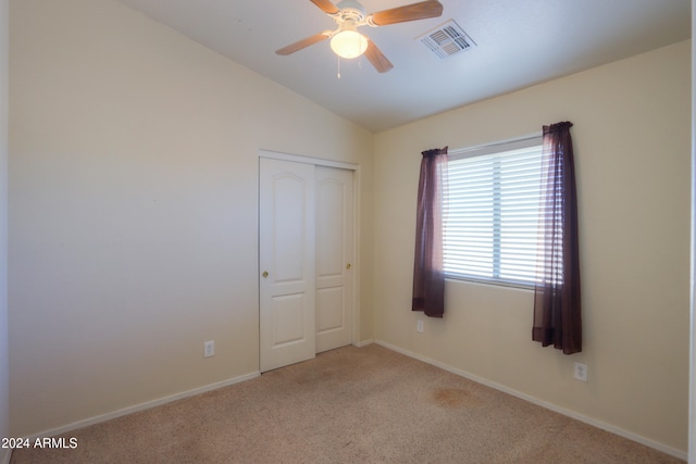 carpeted empty room with lofted ceiling and ceiling fan