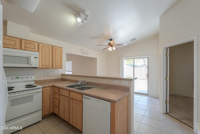 kitchen with white appliances, sink, kitchen peninsula, vaulted ceiling, and light tile patterned floors