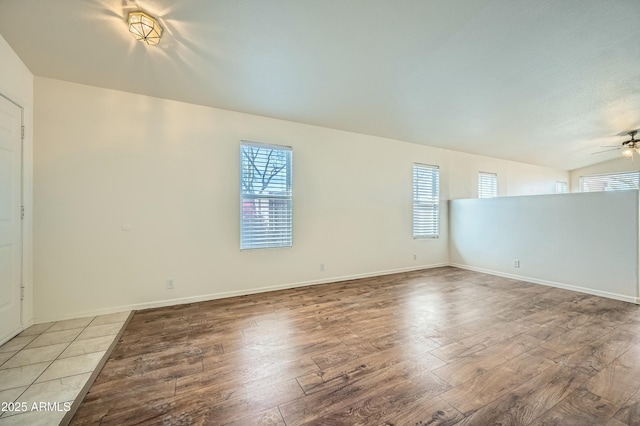 empty room with ceiling fan, hardwood / wood-style floors, and a wealth of natural light