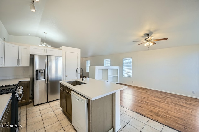 kitchen with sink, range with gas cooktop, stainless steel fridge, dishwasher, and white cabinets