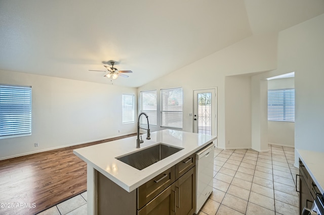 kitchen with dishwasher, lofted ceiling, sink, a kitchen island with sink, and light tile patterned floors