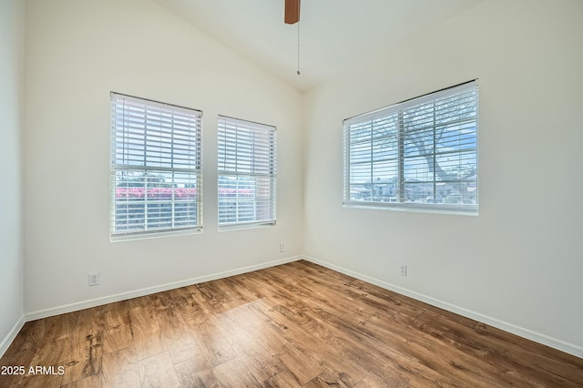 spare room with vaulted ceiling, wood-type flooring, a wealth of natural light, and ceiling fan