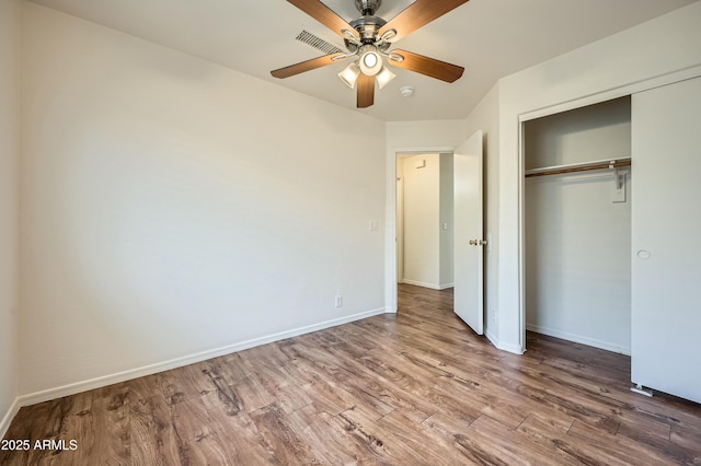 unfurnished bedroom with wood-type flooring, ceiling fan, and a closet