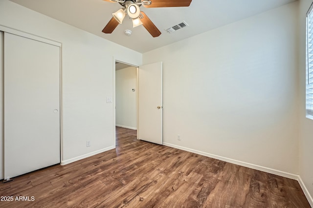 unfurnished bedroom featuring hardwood / wood-style floors, ceiling fan, and a closet