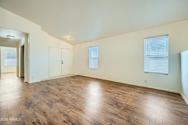 spare room with lofted ceiling and wood-type flooring