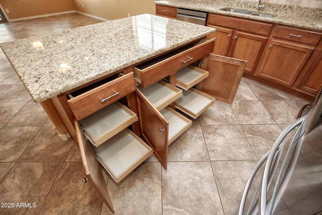 kitchen featuring sink, light tile patterned floors, light stone countertops, and dishwasher