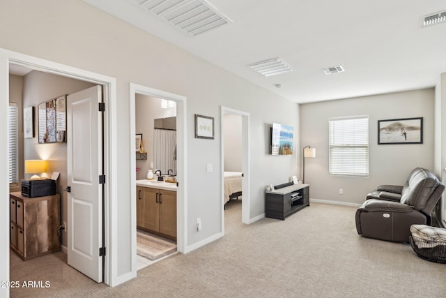 sitting room featuring light colored carpet and sink