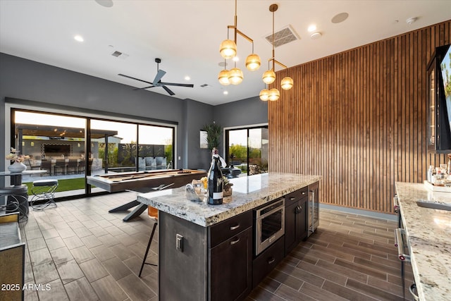 26690 N 119th St, Scottsdale, AZ 85262 - kitchen with visible vents, a kitchen bar, stainless steel microwave, a ceiling fan, and open floor plan