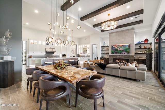 26690 N 119th St, Scottsdale, AZ 85262 - dining area with beam ceiling, a fireplace, wood finish floors, a towering ceiling, and recessed lighting