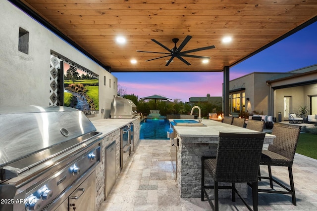 26690 N 119th St, Scottsdale, AZ 85262 - patio terrace at dusk with an outdoor living space, ceiling fan, grilling area, and an outdoor kitchen