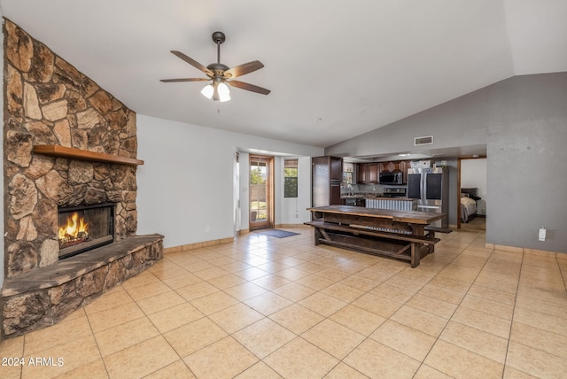 tiled living room with ceiling fan, a fireplace, and lofted ceiling