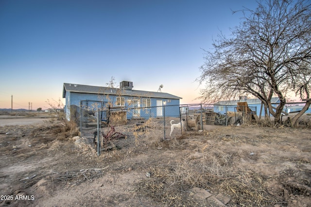 rear view of house with cooling unit, fence, and stucco siding