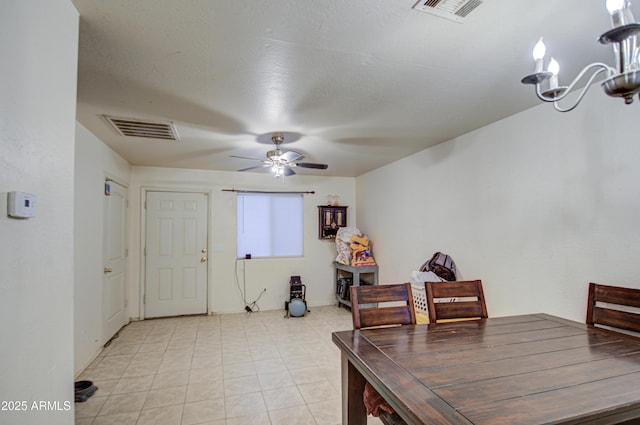 dining area featuring light tile patterned floors, visible vents, and ceiling fan with notable chandelier