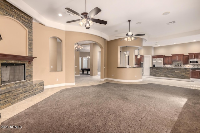 unfurnished living room with light carpet, visible vents, and a stone fireplace