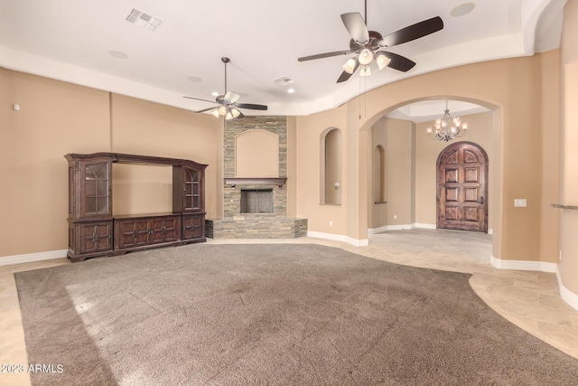 unfurnished living room with ceiling fan, a fireplace, visible vents, and baseboards