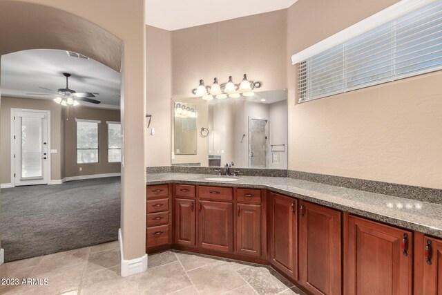 full bathroom with visible vents, a shower, baseboards, ceiling fan, and vanity