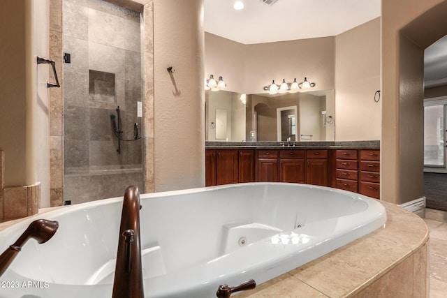 bathroom featuring a tub with jets, tiled shower, and vanity