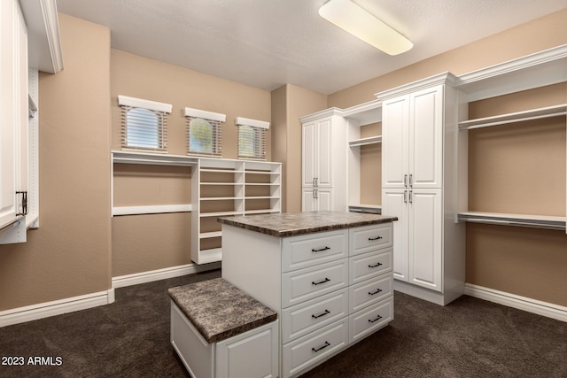 spacious closet with dark carpet