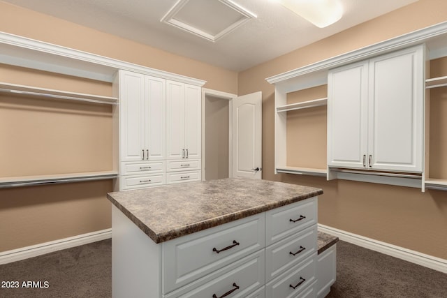 walk in closet featuring dark colored carpet and attic access