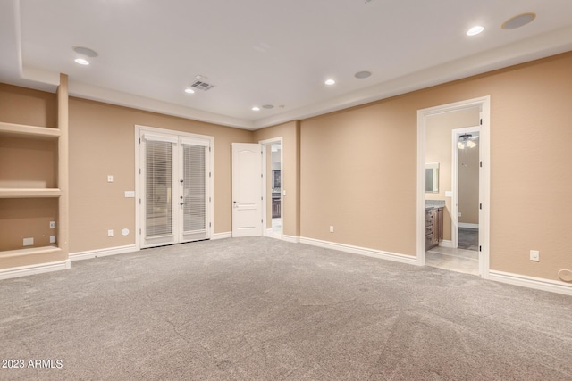 carpeted spare room with baseboards, visible vents, french doors, built in shelves, and recessed lighting