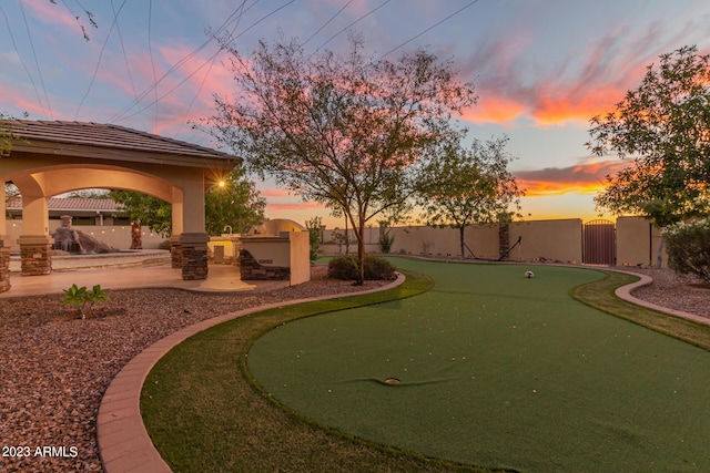 view of yard with an outdoor kitchen, a gazebo, a gate, a patio area, and a fenced backyard