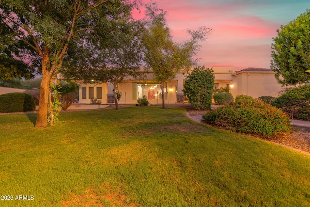 view of front of home featuring a lawn and stucco siding