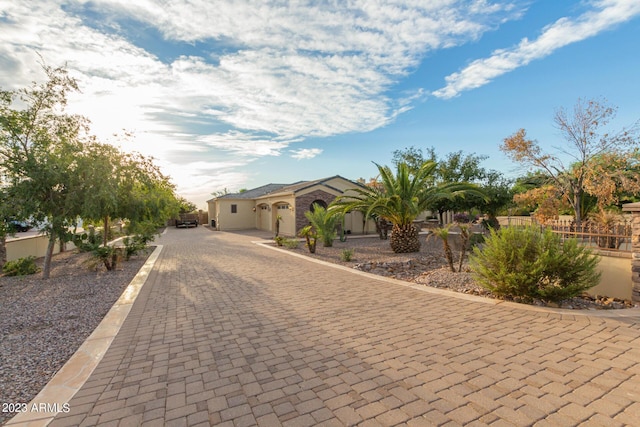 view of front of house featuring decorative driveway and fence