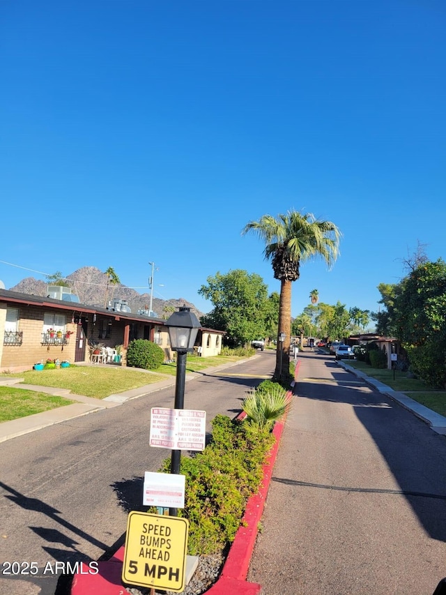 view of asphalt road featuring curbs and sidewalks