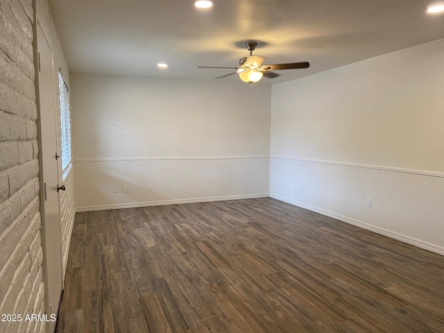 empty room with ceiling fan, dark wood finished floors, a wainscoted wall, recessed lighting, and baseboards