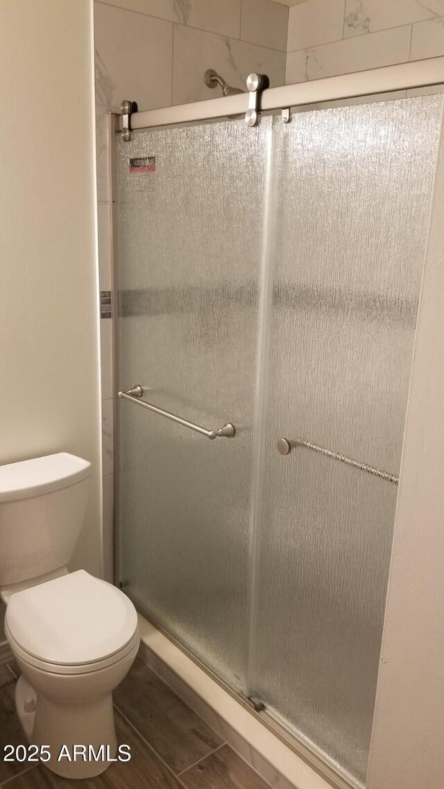 full bath with toilet and a shower stall