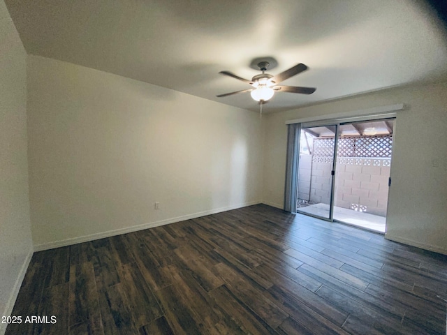spare room featuring dark wood finished floors, ceiling fan, and baseboards