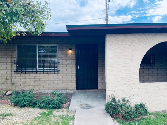 entrance to property featuring brick siding