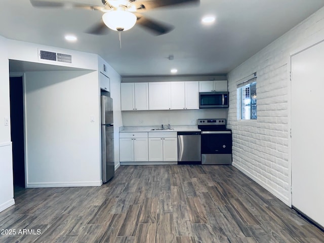 kitchen with stainless steel appliances, white cabinets, a ceiling fan, dark wood-type flooring, and light countertops