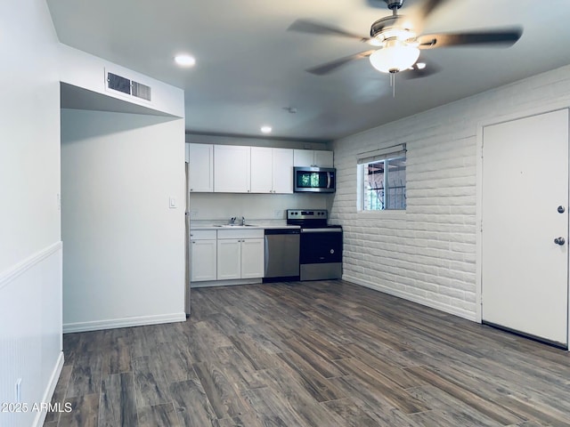 kitchen with stainless steel appliances, a sink, white cabinetry, ceiling fan, and dark wood-style floors