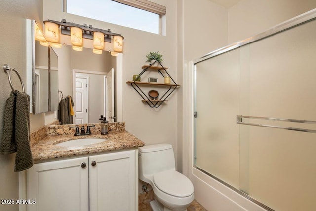 full bathroom with vanity, toilet, and combined bath / shower with glass door