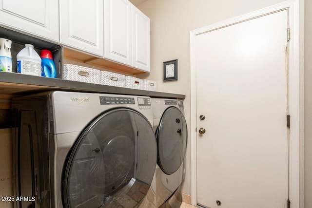 washroom featuring cabinets and washer and clothes dryer