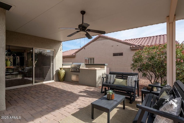 view of patio / terrace featuring ceiling fan, area for grilling, and exterior kitchen