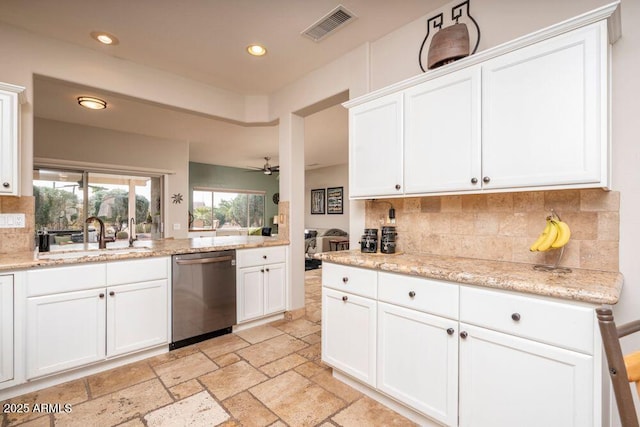 kitchen featuring white cabinetry, sink, stainless steel dishwasher, and light stone counters