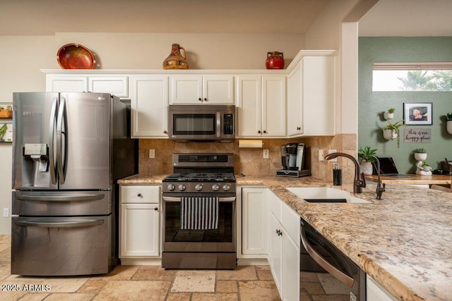 kitchen featuring white cabinetry, appliances with stainless steel finishes, sink, and decorative backsplash