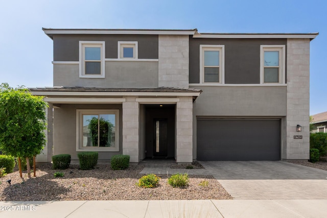 view of front of house featuring a garage, stucco siding, and driveway