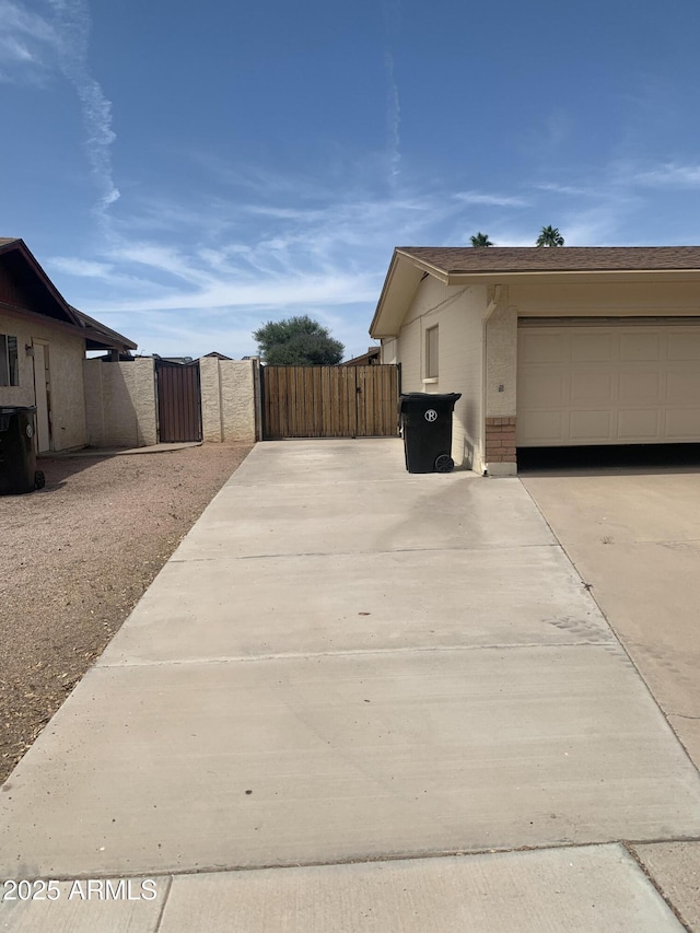 108 E Jasmine St, Mesa, AZ 85201 - view of property exterior featuring a gate, concrete driveway, brick siding, and an attached garage