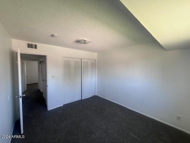 4332 W Ocotillo Rd Unit 206, Glendale, AZ 85301 - unfurnished bedroom with dark colored carpet, a textured ceiling, and a closet