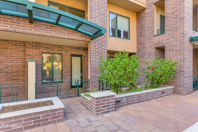 view of exterior entry featuring a patio area