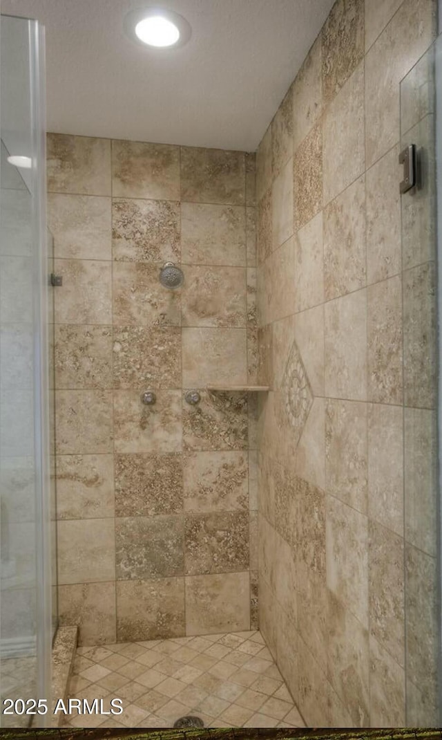 interior details featuring tiled shower