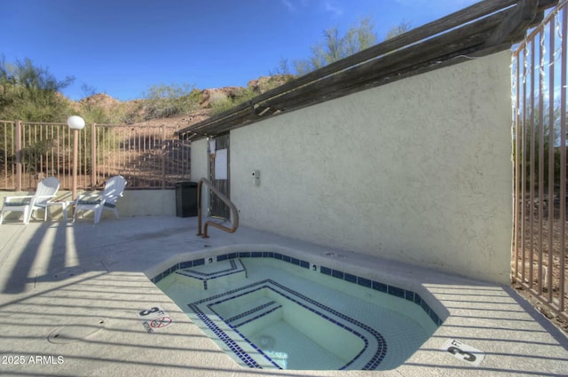 view of swimming pool featuring a patio area and an in ground hot tub