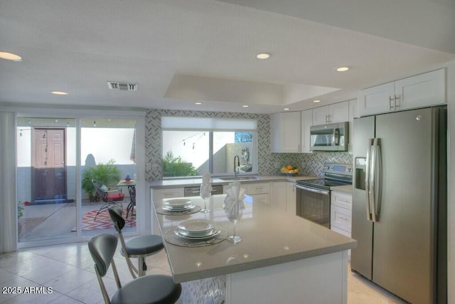 kitchen featuring a wealth of natural light, white cabinetry, and appliances with stainless steel finishes