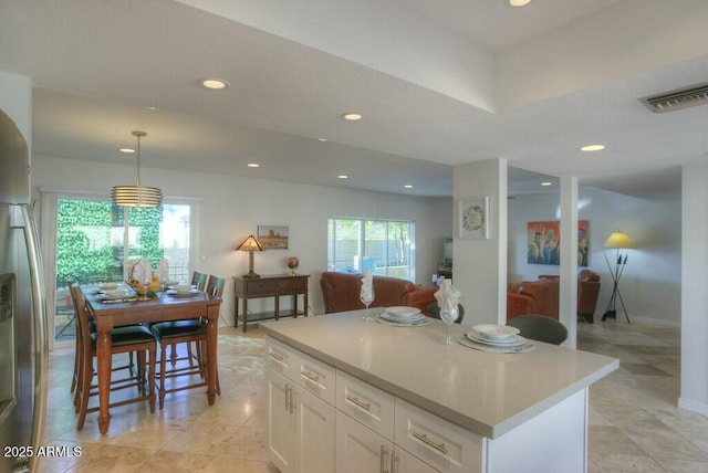 kitchen featuring pendant lighting, a center island, and white cabinetry