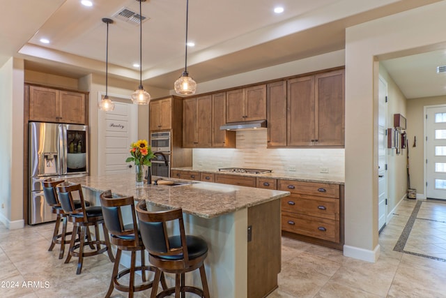 kitchen with brown cabinetry, baseboards, stainless steel appliances, and visible vents