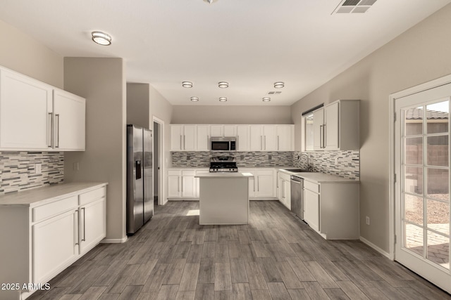 kitchen with white cabinetry, sink, a kitchen island, and appliances with stainless steel finishes